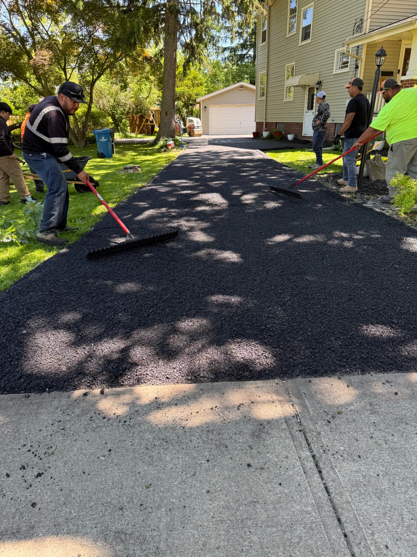 Crew installing new asphalt driveway