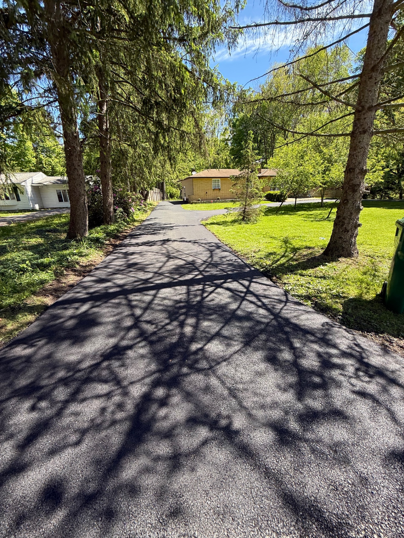 Long tree lined resurfaced asphalt driveway