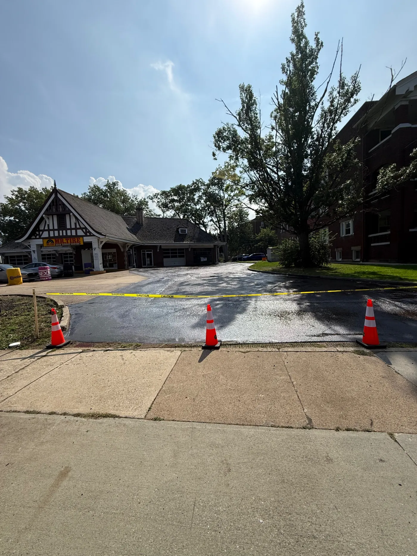 Freshly sealcoated commercial parking lot at a Mr. Tire auto service center in Lakewood, Ohio