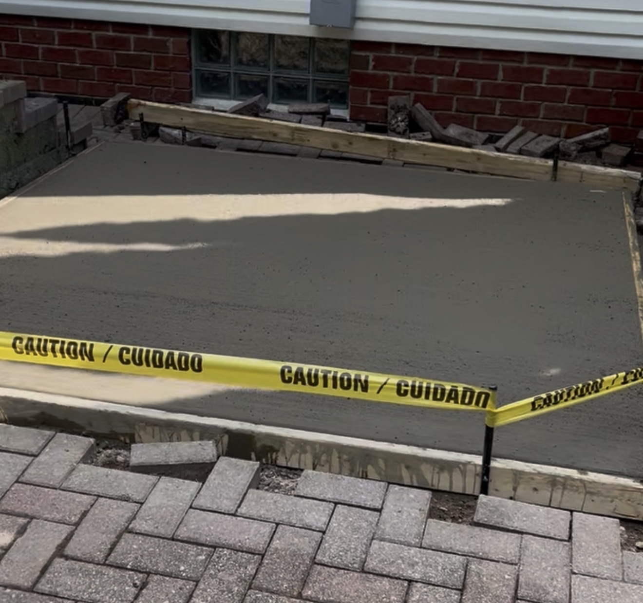 Freshly poured concrete patio pad with caution tape