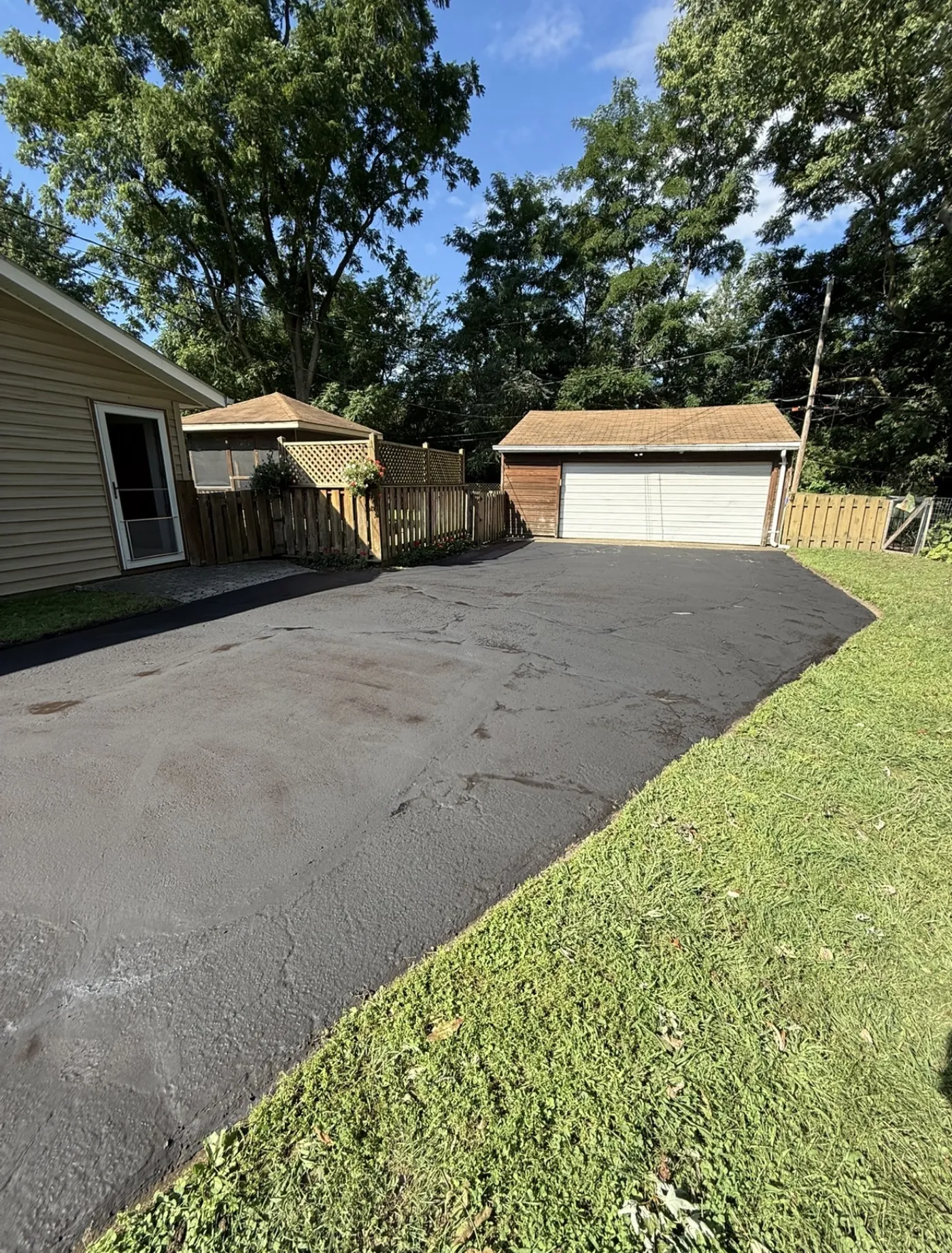 Freshly sealcoated rear asphalt parking pad in Painesville, Ohio