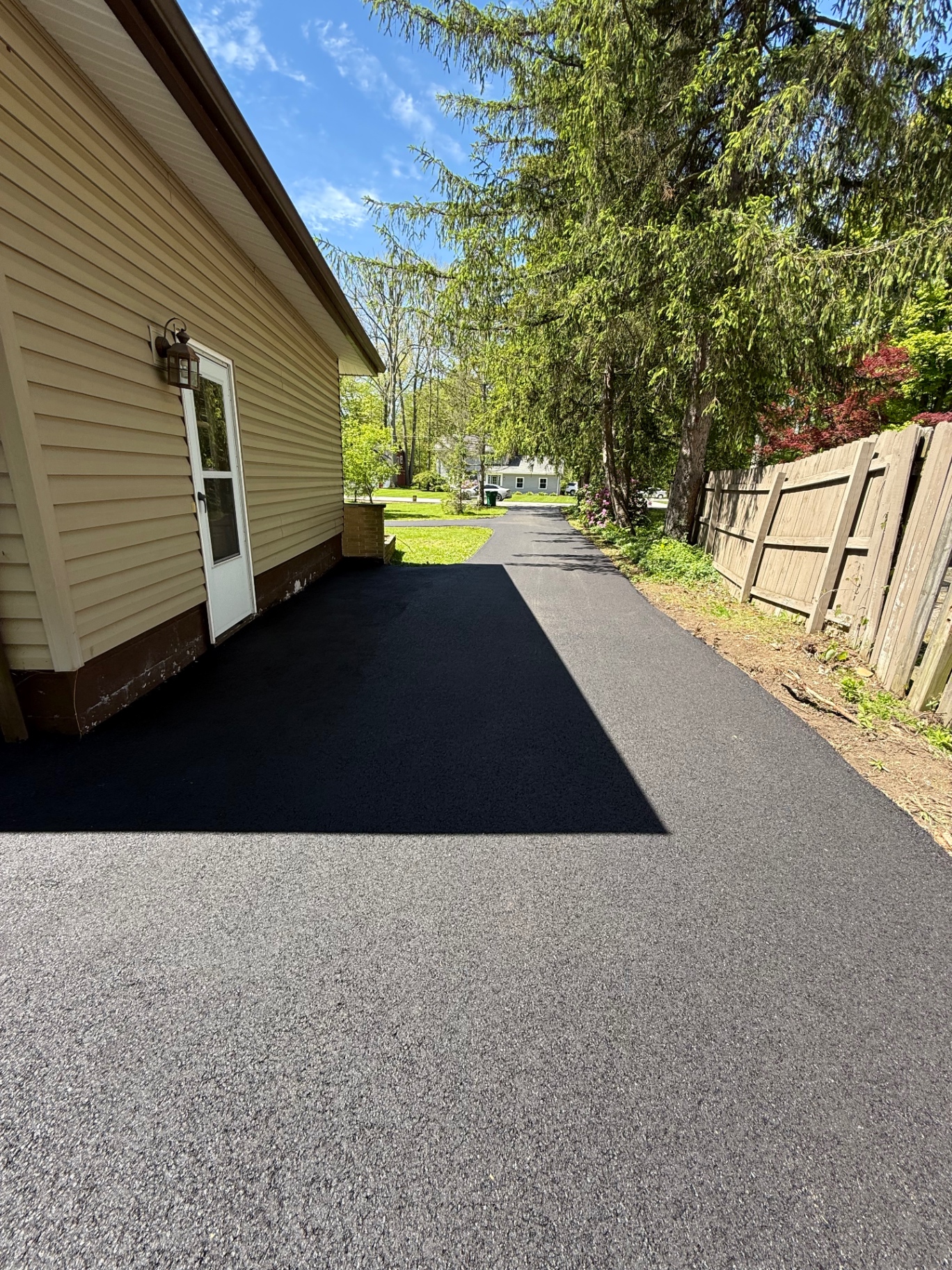 Resurfaced asphalt driveway alongside home