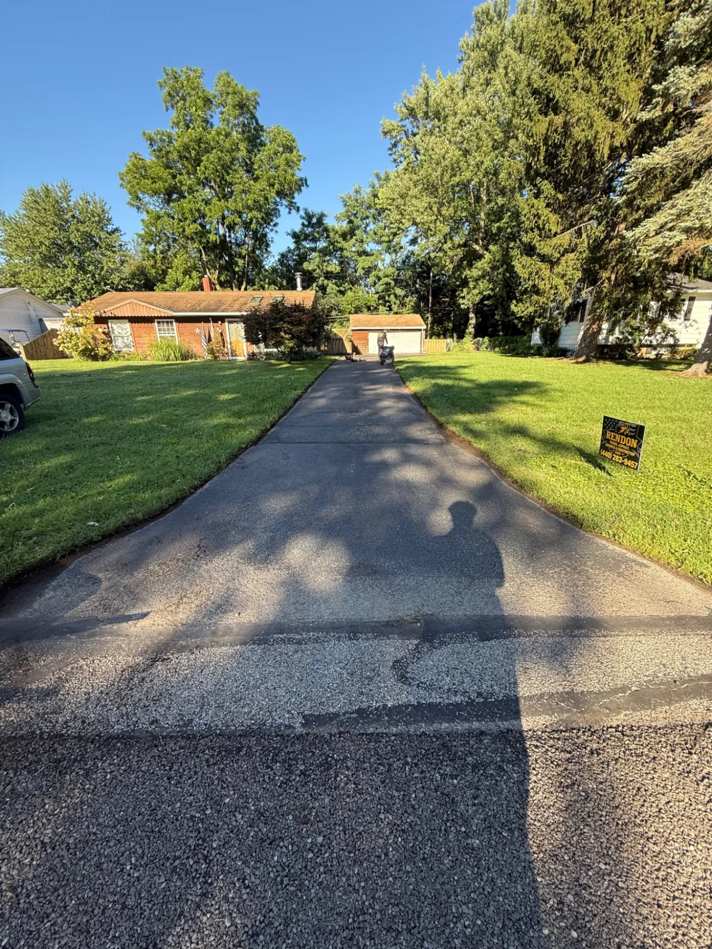 Before: driveway sealcoating in Painesville, OH, faded gray asphalt driveway