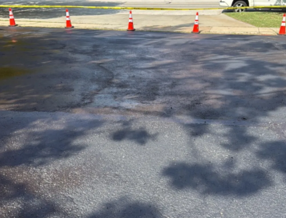 After: street side entrance apron at a Mr. Tire shop in Lakewood, OH, sealcoated to a clean edge at the sidewalk by Rendon Paving