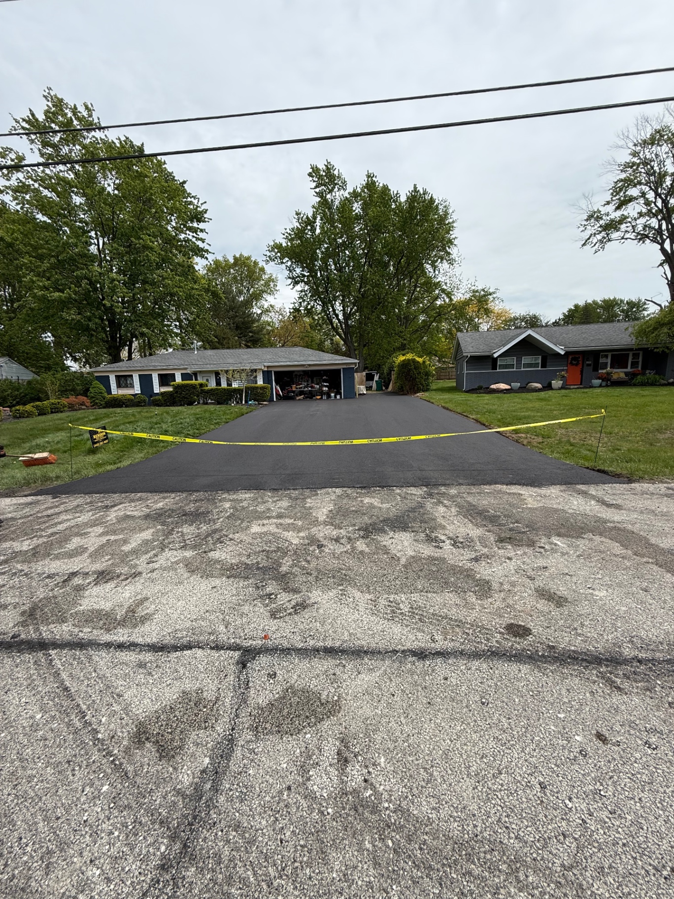 Resurfaced asphalt driveway with caution tape