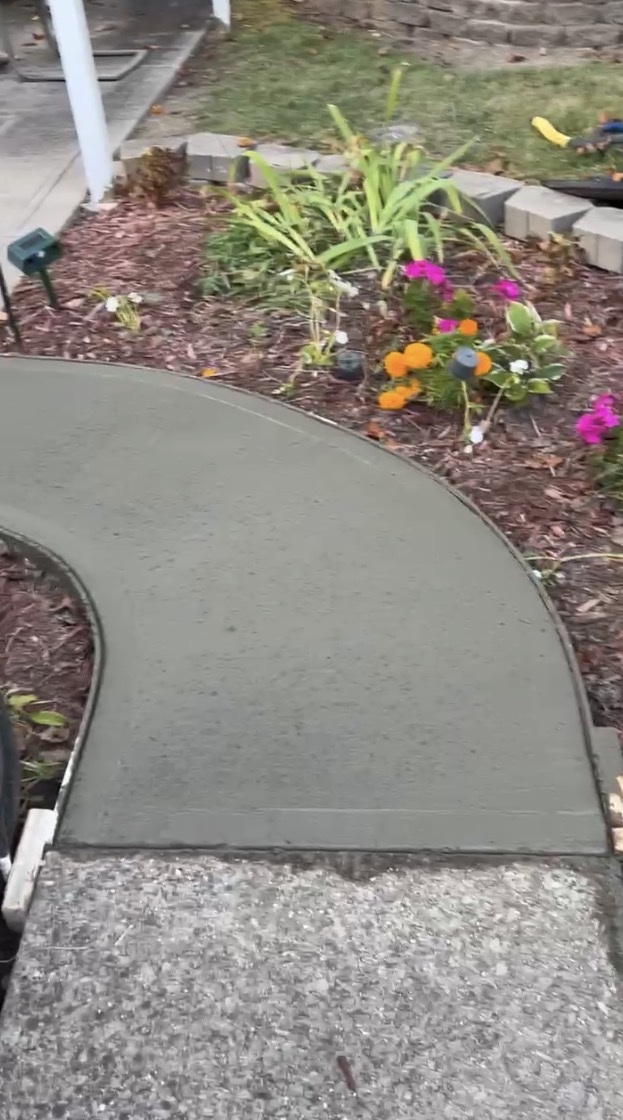 Curved concrete walkway through garden